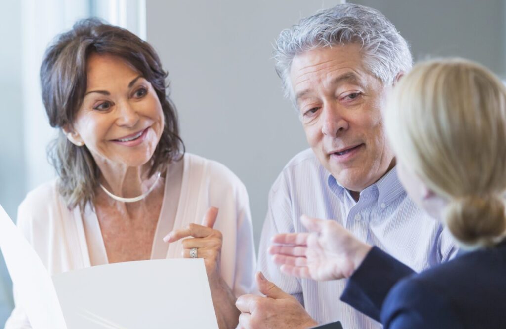 A senior couple sitting down with a financial advisor to discuss their retirement plan.